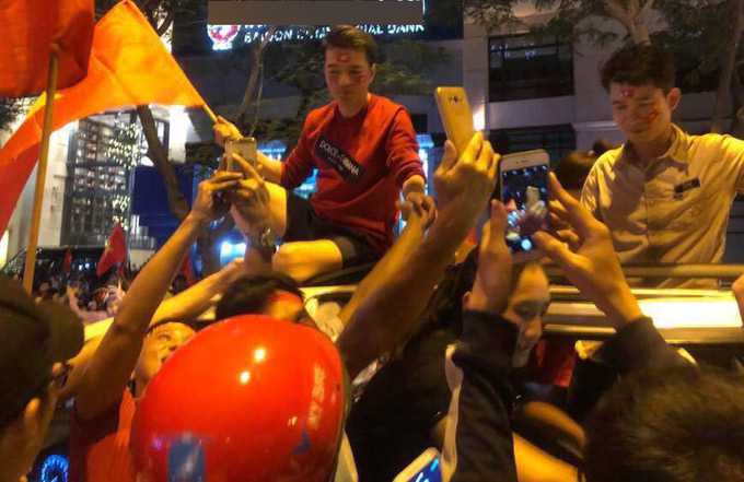 Ca sĩ nổi tiếng ngồi vắt vẻo trên nóc ôtô xem người dân hồ hởi mừng chiến thắng của đội tuyển U23 Việt Nam trong trận bán kết gặp Qatar.