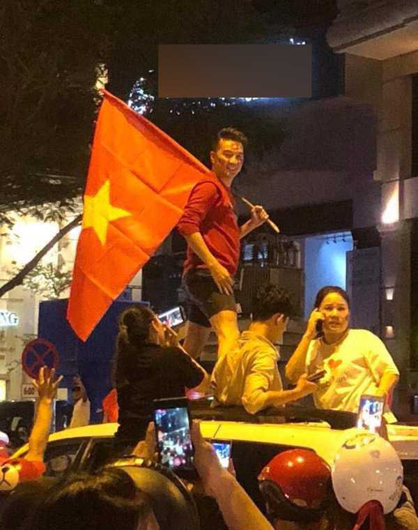 Đàm Vĩnh Hưng mặc quần short, cầm cờ đỏ sao vàng xuống đường đi bão.