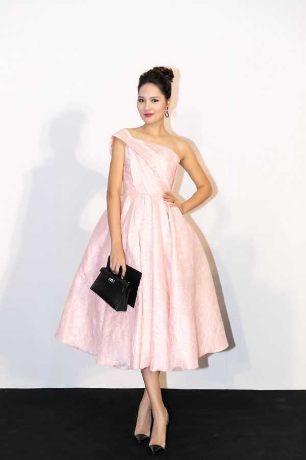 Hoa hậu Hương Giang chọn sắc hồng pastel để xuất hiện tại sự kiện. Chiếc váy xoè nữ tính được Hương Giang phối cùng túi Hermes màu đen, thiết kế đơn giản.